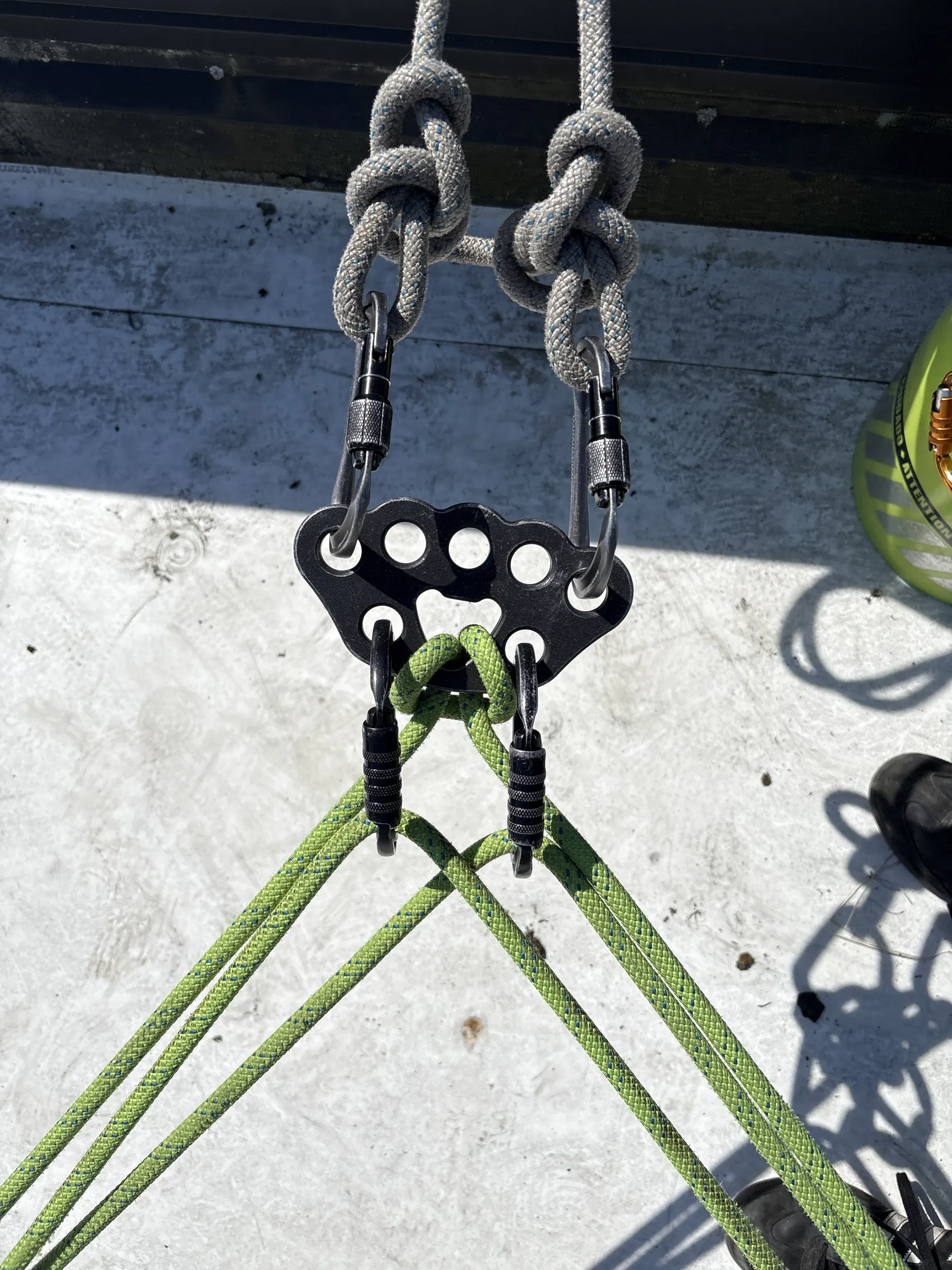 Rigging plate, carabiners and rope knots anchored on a rooftop