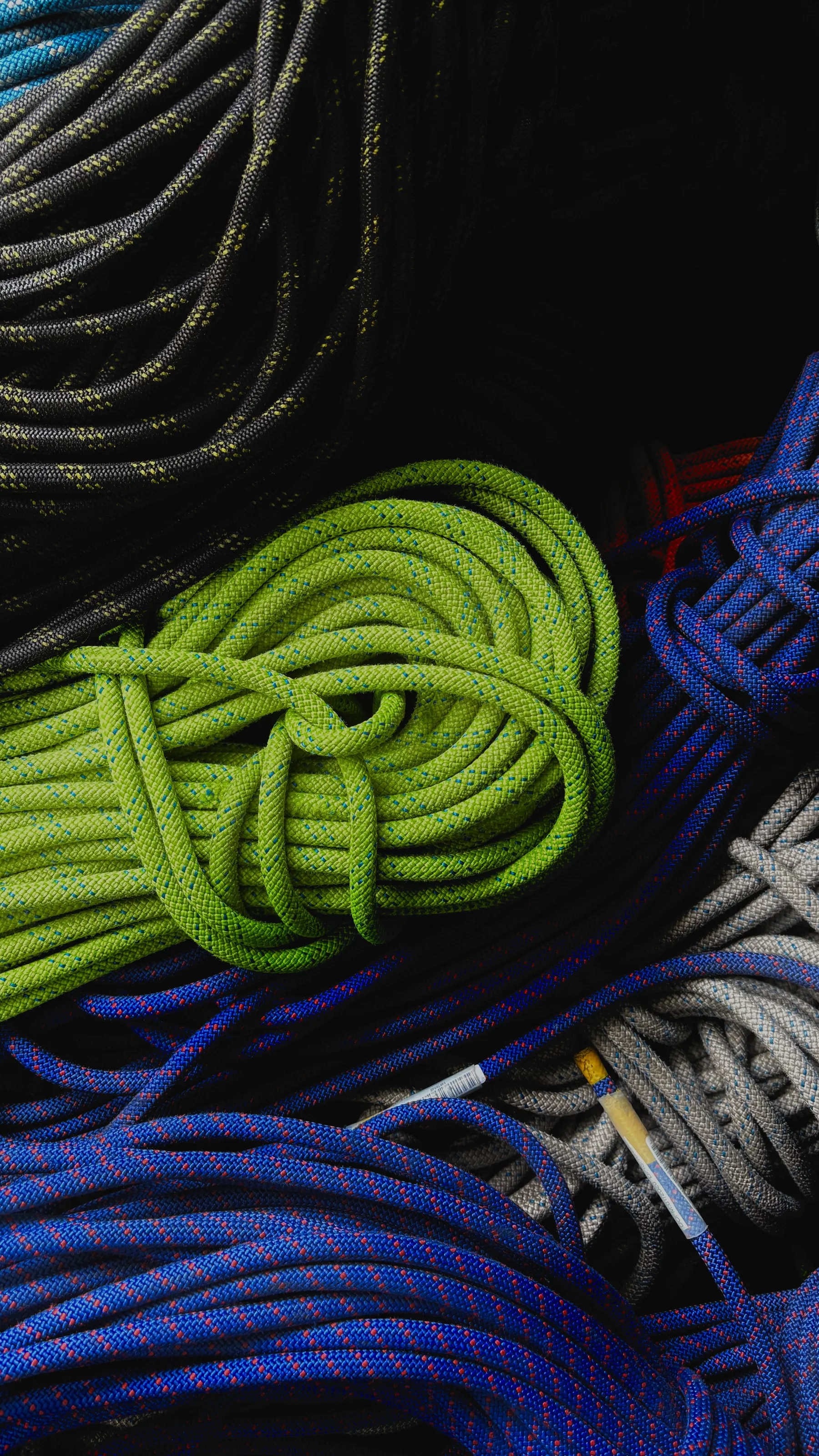 Coils of climbing rope in green, blue, grey and black