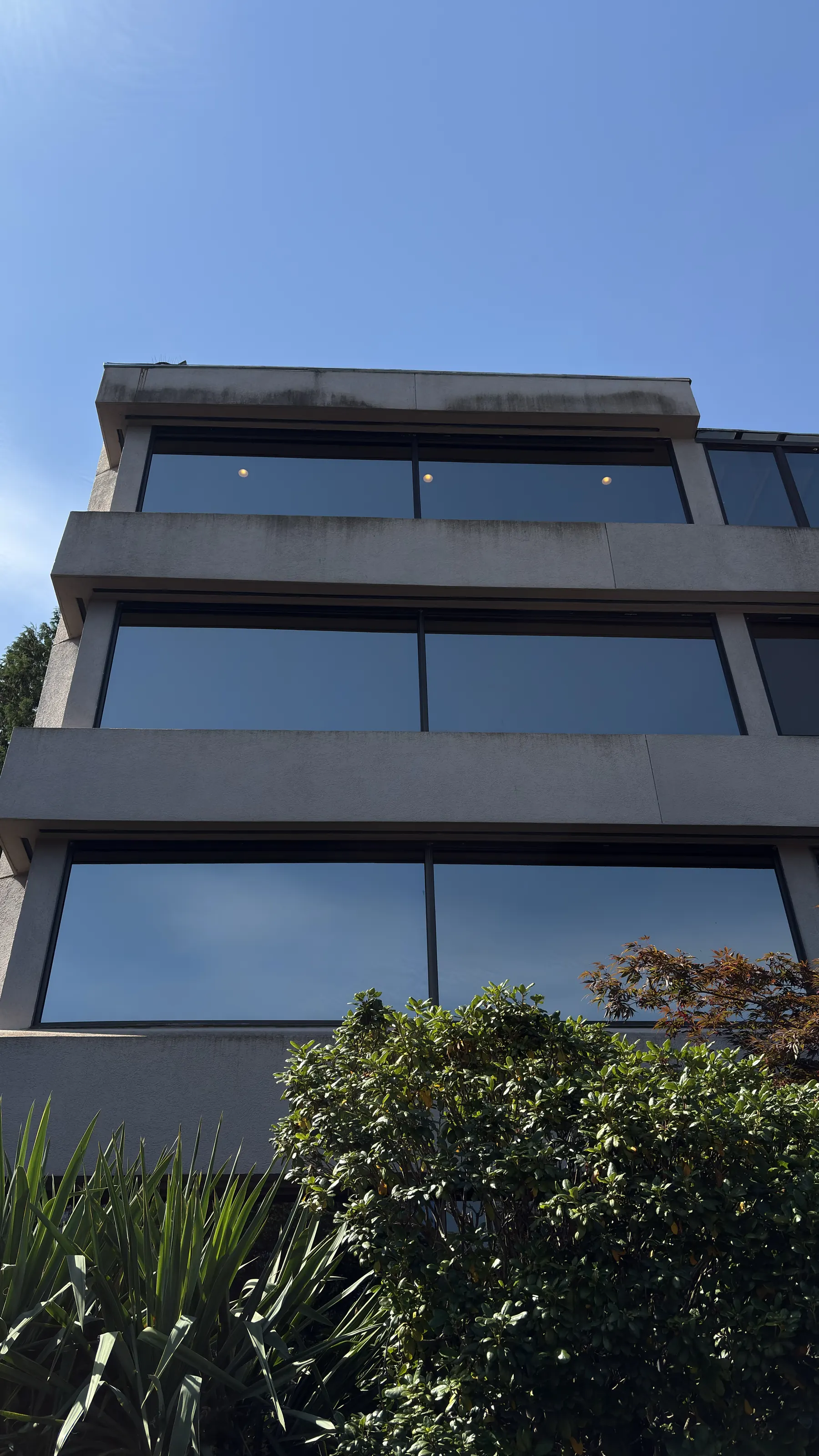 Concrete band on a building stained with dirt and algae before soft washing